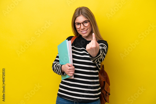 Young student woman isolated on yellow background background doing coming gesture