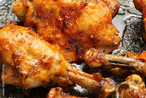 roasted chicken legs with aromatic crust, baked meat on a oven tray, tasty food close view