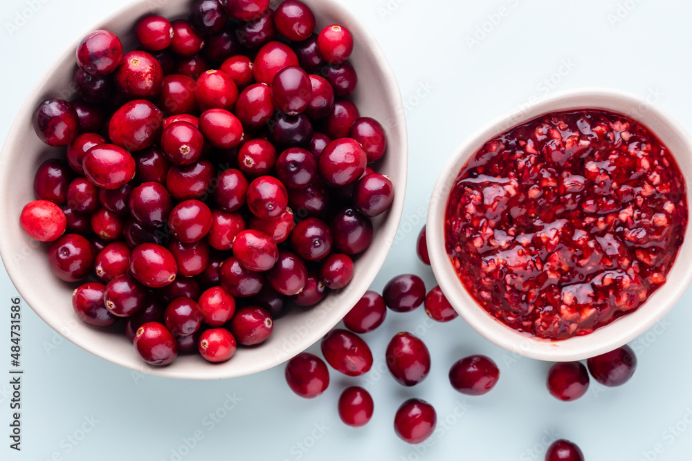 Cranberries in white bowl on pastel background. Cranberries in white bowl on pastel background.