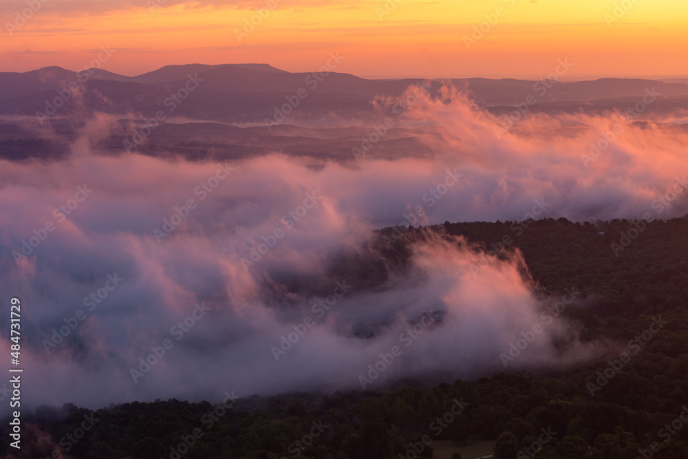 Colorful morning sunrise with golden glowing fog clouds over mountains at Arkansas Grand Canyon Scenic Point Overlook 