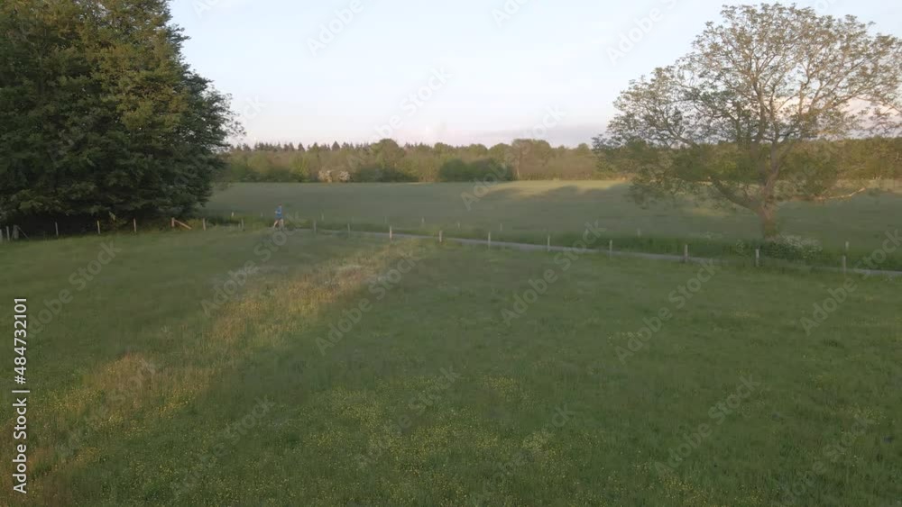 An aerial shot of a person jogging along a trail in the countryside An aerial shot of a person jogging along a trail in the countryside