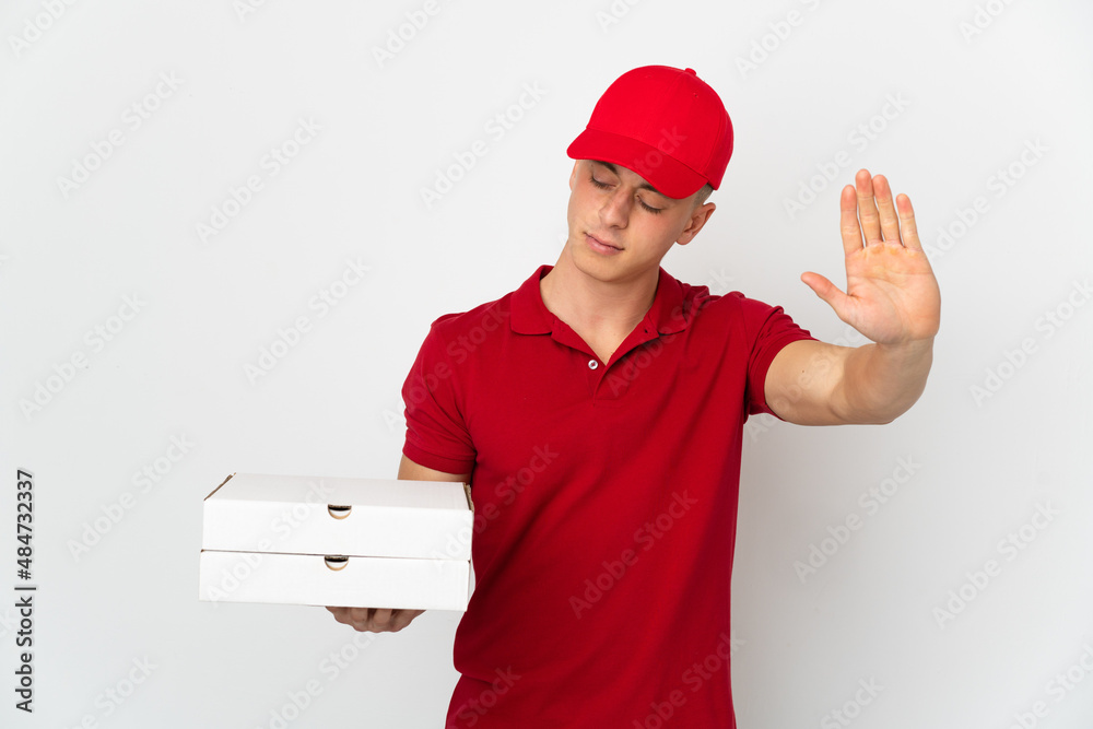 Pizza delivery man with work uniform picking up pizza boxes isolated on white background making stop gesture and disappointed Pizza delivery man with work uniform picking up pizza boxes isolated on white background making stop gesture and disappointed