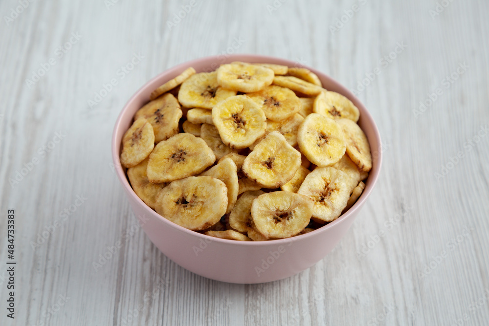 Homemade Banana Chips in a Pink Bowl, side view. Homemade Banana Chips in a Pink Bowl, side view.