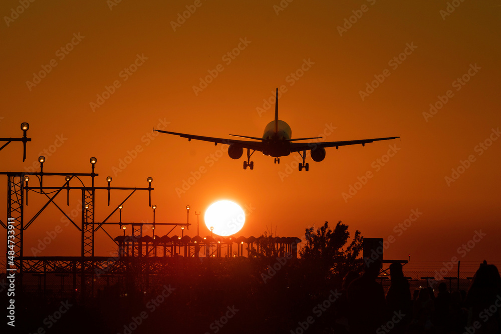 Airplane landing with the sun nearby Airplane landing with the sun nearby