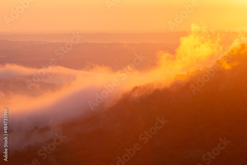 Colorful morning sunrise with golden glowing fog clouds over mountains at Arkansas Grand Canyon Scenic Point Overlook 