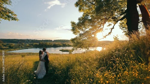 Wallpaper Mural A happy young couple spends an hour at the lake at sundown. The warm sunset of the sun and the edge of the nature of that lake. The woman in arms closed her eyes and enjoys the receiving moments of Torontodigital.ca