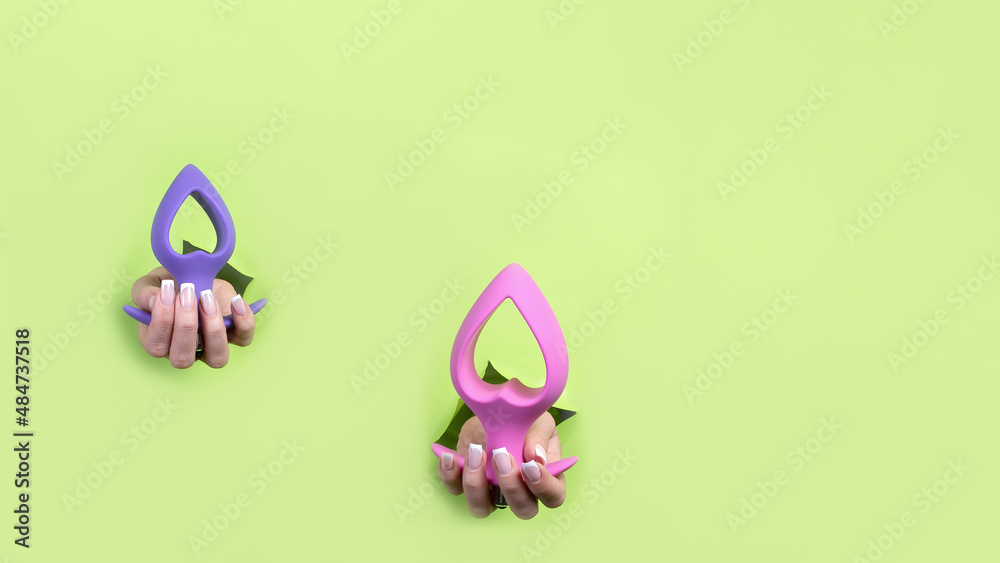 A sex toy on a green background. A place to copy. Satisfaction and relaxation for adults. Sex shop ideas. Banner