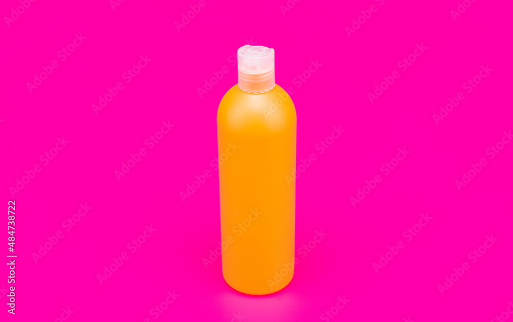 orange shampoo bottle on pink background, hygiene orange shampoo bottle on pink background, hygiene
