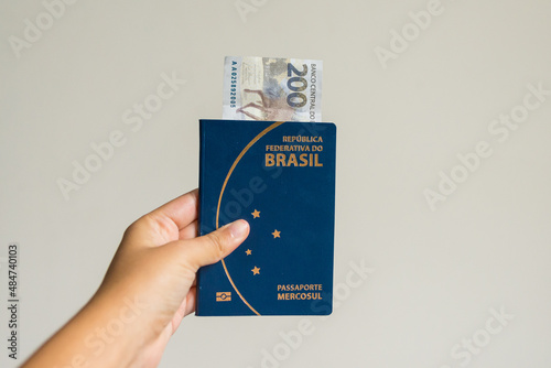Passaporte brasileiro com dinheiro em fundo branco photo