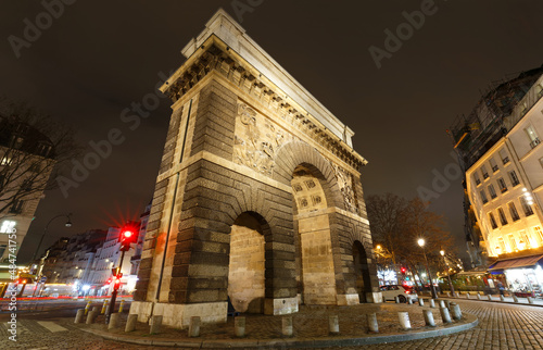 Fototapeta Naklejka Na Ścianę i Meble -  Paris, the porte Saint-Martin, beautiful ancient gate near the Grands Boulevards at night.