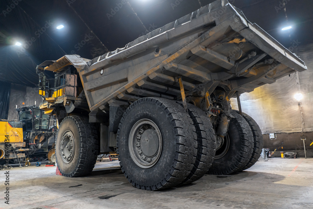 Dump truck is serviced in an industrial garage.