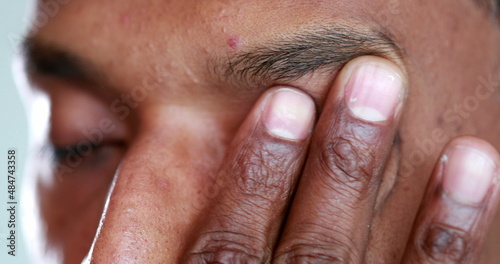 Tired man rubbbing eye with hand. Exhausted african american touching face