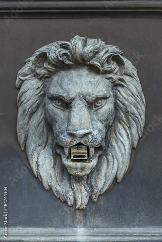 concrete sculpture of the head of a formidable lion on the facade of the fountain