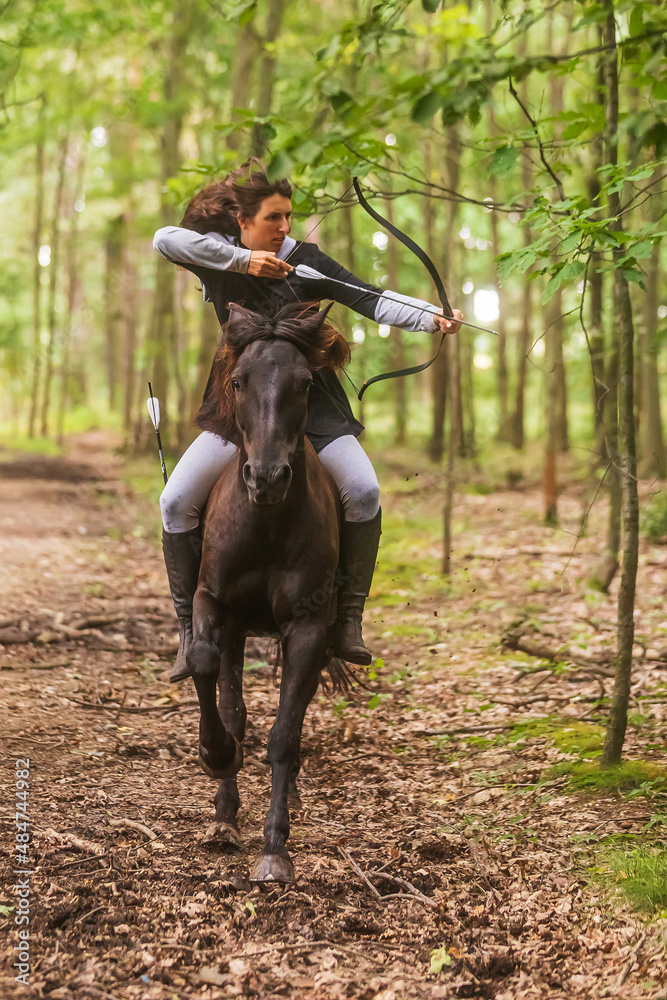 beautiful woman with long hair woman on a horse shooting a bow beautiful woman with long hair woman on a horse shooting a bow