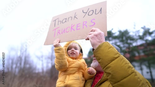 Portrait of people supporting the movement against mandatory vaccination by Freedom Convoy. Grandfather and grandson holding a sign Thank you truckers photo