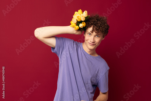 cute teen holding a yellow bouquet of flowers purple t-shirts isolated background unaltered