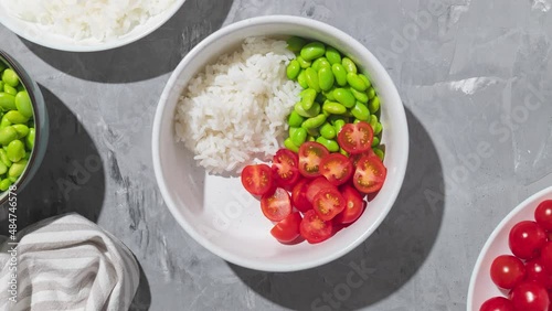Hawaiian poke bowl with shrimps, rice and vegetables. Healthy bowl with prawns, rice, edamame beans, tomato and avocado. Stop motion animation. photo