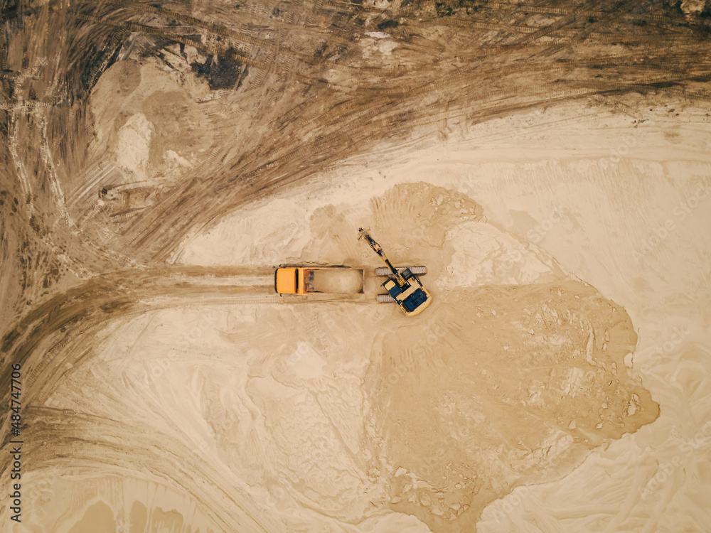 Excavator loading sand into a truck body in Sand quarry, industrial ...