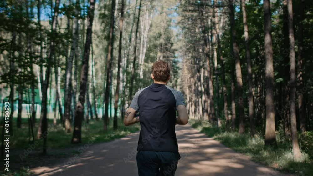 Camera follows young man run in park, athletic healthy lifestyle. Man training for marathon or running competition. Cardio workout routine Camera follows young man run in park, athletic healthy lifestyle. Man training for marathon or running competition. Cardio workout routine