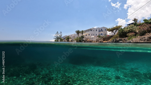 Underwater split photo of small bay and pituresque village of Avlemonas with emerald crystal clear sea in island of Kythira, Ionian, Greece