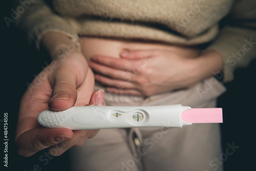 A woman sees a positive pregnancy test result.
