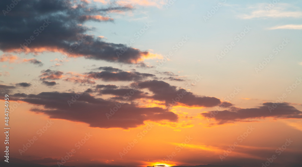 Fantastic bright clouds in the sunset sky. 
Sky background.