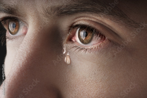 Photo Closeup of young crying man eyes with a tears