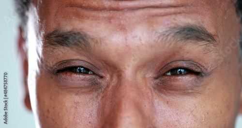 African man eyes squinting. Close-up black guy closing eyes squint