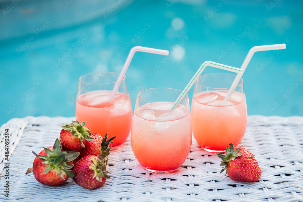 three strawberry cocktails by the pool