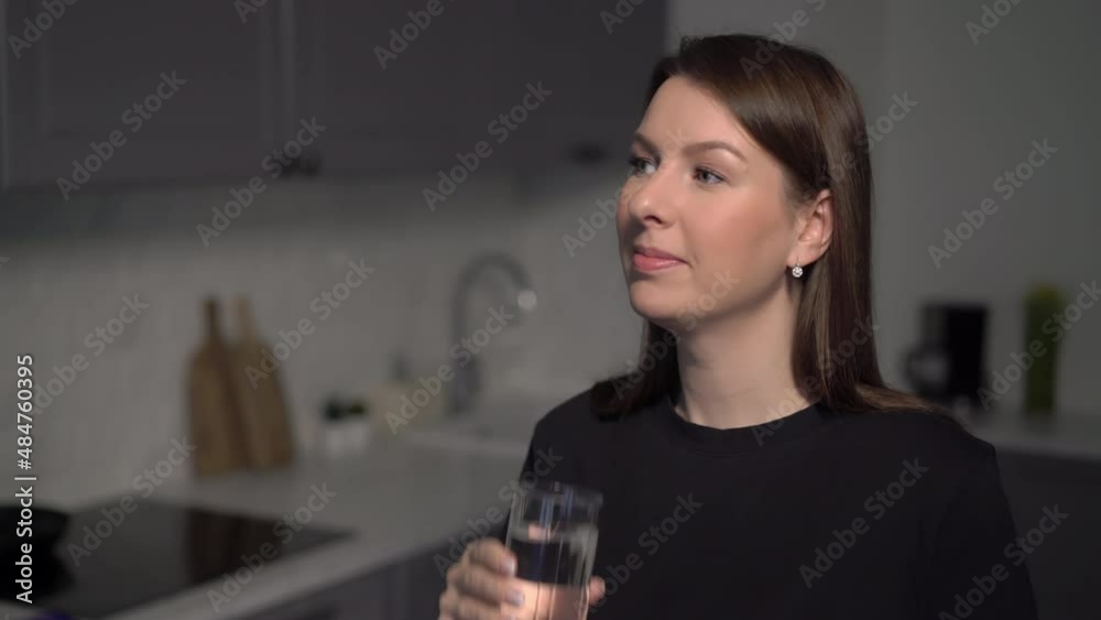 A young woman is holding a glass of clean water. The girl drinks water. A young woman is holding a glass of clean water. The girl drinks water.