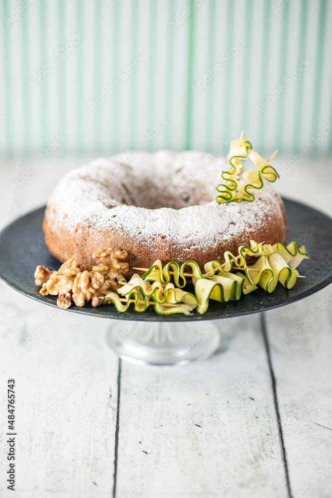 A zucchini and walnut cake decorated with ingredients