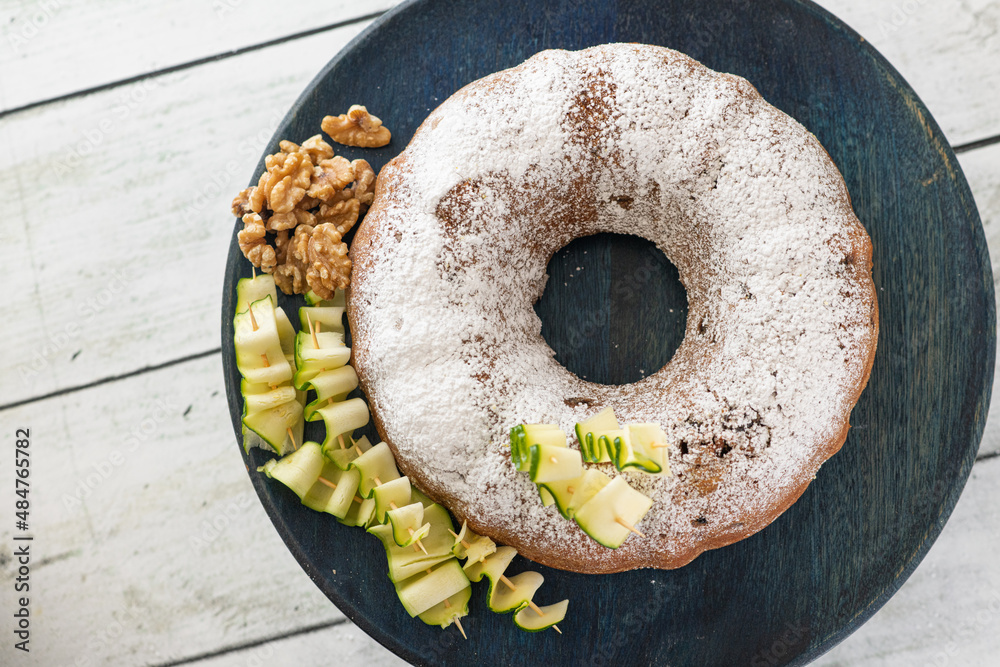 A zucchini and walnut cake decorated with ingredients