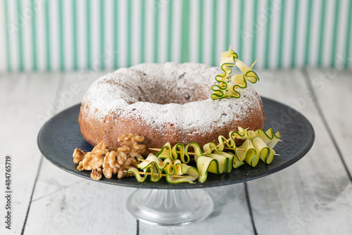 A zucchini and walnut cake decorated with ingredients