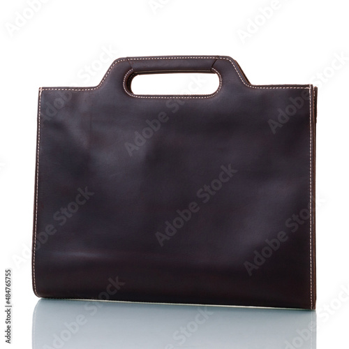 Brown leather bag of rectangular shape with cut-through handles. On a white background