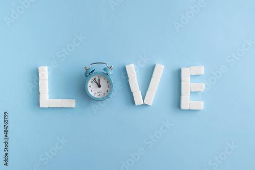 Valentine day composition. Love letters with blue alarm clock. Blue background. photo