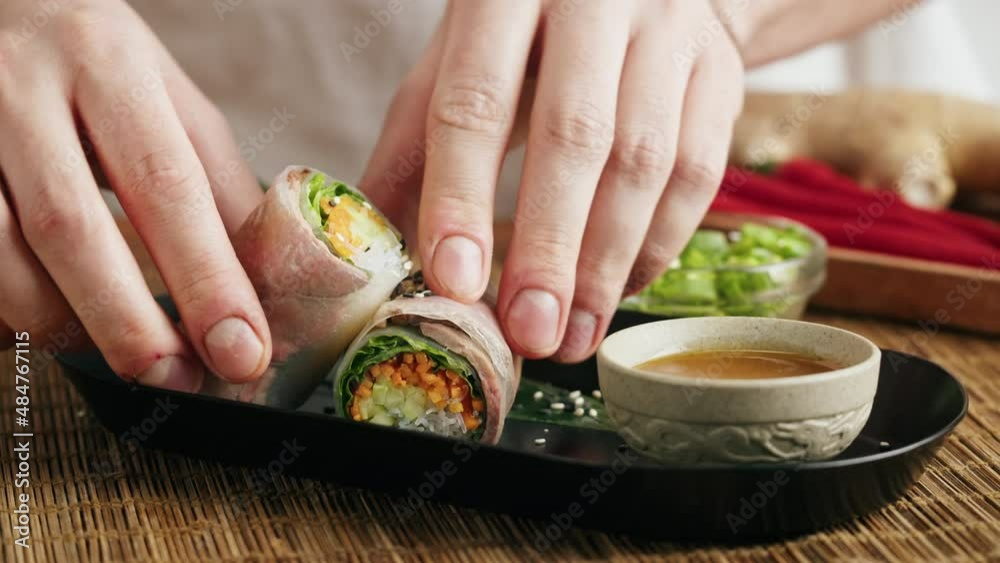 Spring roll with chicken or shrimps in rice paper with sweet and sour sauce close-up, cooking traditional korean chinese food. Tasty vietnamese cuisine.