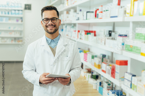 Portrait of a handsome pharmacist working in a pharmacy photo