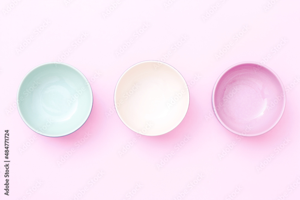 Obraz premium Empty color bowls isolated on pink background. Top view.