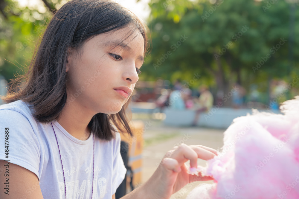 Obraz premium Adorable little sisters eating candy-floss outdoors at summer
