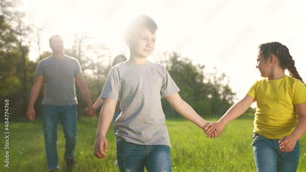 people in the park. happy family kid walk at sunset. mom dad and daughter baby walk holding dream hands in the park. happy family kid concept. parents and fun children. people walk in a green park people in the park. happy family kid walk at sunset. mom dad and daughter baby walk holding dream hands in the park. happy family kid concept. parents and fun children. people walk in a green park