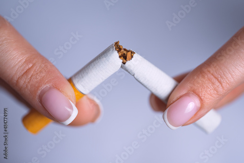 Closeup woman hands with broken cigarette. Stop smoking, quit smoking or no smoking concept photo