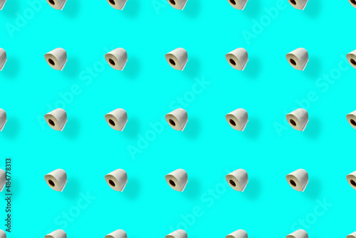 Colorful pattern of rolls of a white toilet paper isolated on blue background. Top view. Wallpaper for bathroom