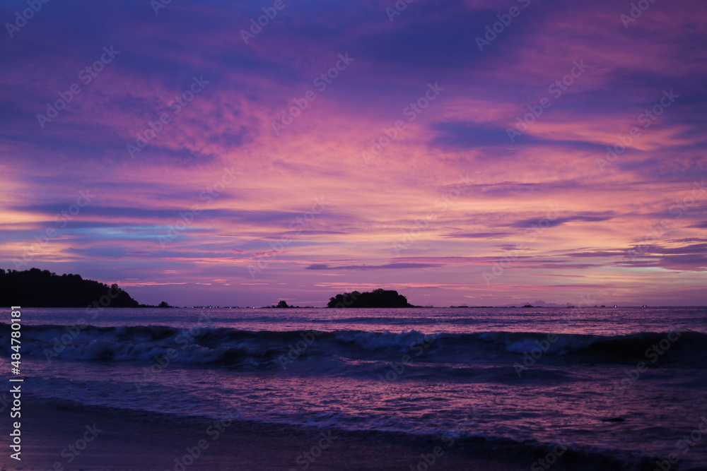 Beautiful sunset with the purple and orange sky on the twilight period at Palangpang Beach Sukabumi, West Java, Indonesia.