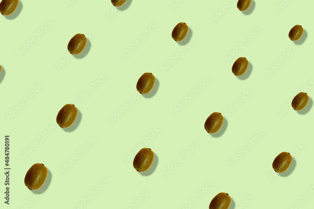 Colorful fruit pattern of fresh kiwi on light green background with shadows. Top view. Flat lay. Pop art design Colorful fruit pattern of fresh kiwi on light green background with shadows. Top view. Flat lay. Pop art design