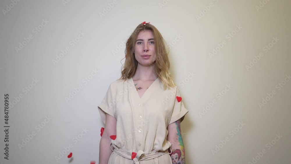 Beautiful girl throws up small paper red hearts Beautiful girl throws up small paper red hearts