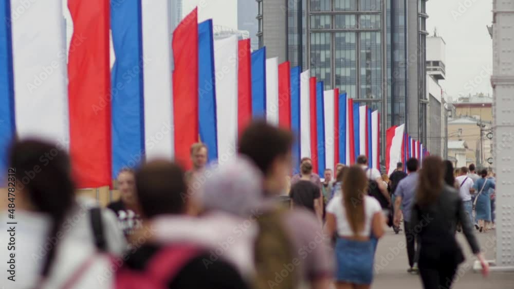 Lots of people walk past the many Russian flags in Moscow