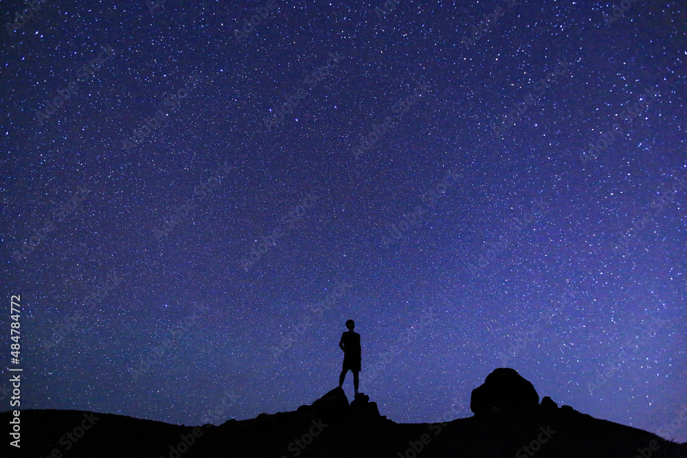 Silhouette of men / boy on the hill. Stargazing at Oahu island, Hawaii. Starry night sky, Milky Way galaxy astrophotography. Silhouette of men / boy on the hill. Stargazing at Oahu island, Hawaii. Starry night sky, Milky Way galaxy astrophotography.
