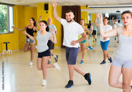 Positive people are dancing boogie-woogie in pairs in modern studio.