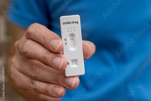 Hands holding Covid-19 rapid antigen test cassette with negative result of rapid diagnostic test