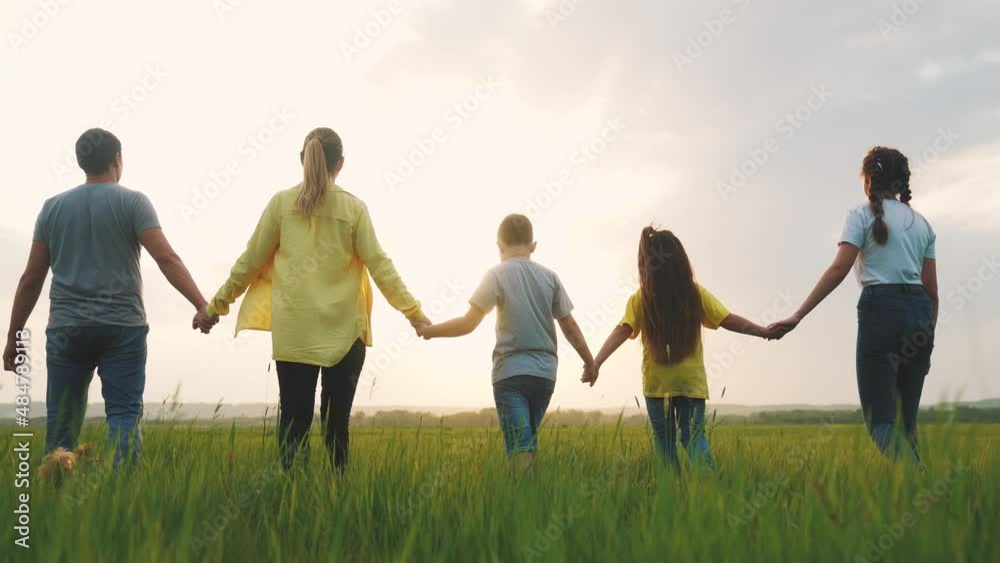 people in the park. happy family a silhouette walk in field. mom dad and daughters, son walk holding hands in park. happy family kid dream concept. fun parents and children walking back silhouette people in the park. happy family a silhouette walk in field. mom dad and daughters, son walk holding hands in park. happy family kid dream concept. fun parents and children walking back silhouette